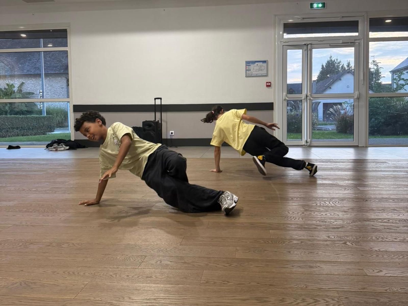 Deux jeunes danseurs en appui sur les mains, jambes tendues, pendant un passage au sol